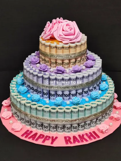 A beautiful three-tier money tower cake with a "Happy Rakhi" message, perfect for spoiling your sister.