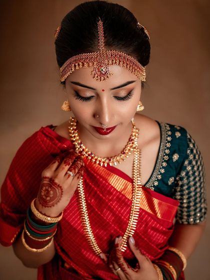 A detailed shot of Manasa's muhurtham eye makeup. The classic gold eyeshadow and bold winged liner are a timeless combination for any South Indian bride.