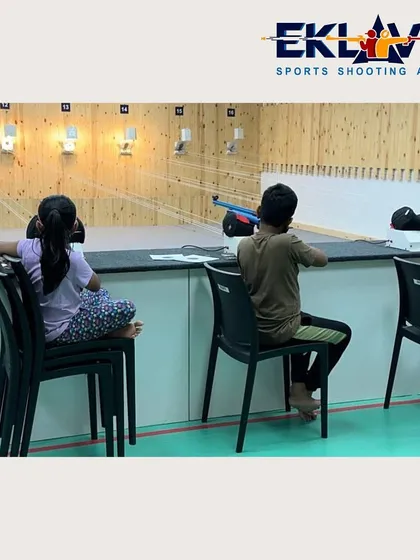 Young shooters seen from behind, completely absorbed in their practice. This view highlights the intense focus that the sport of shooting demands and cultivates.