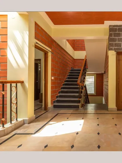 Sunlight streams into a hallway, highlighting the contrast between the smooth flooring and the textured brick and stone walls.