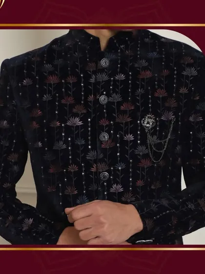 Rule your wedding day in attire fit for royalty. This close-up of a black Bandhgala jacket with intricate floral embroidery showcases how every stitch speaks of elegance and grandeur.
