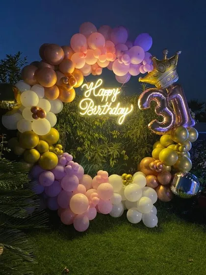 A duplicate image of the outdoor 31st birthday ring setup, showing the beautiful gradient of colors in the balloon arch.