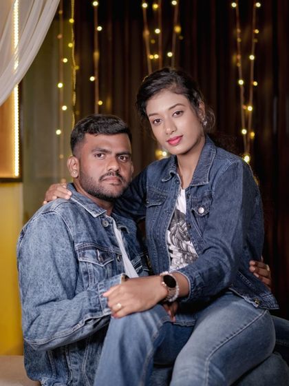 A casual and cool portrait of a couple in matching denim jackets, looking comfortable and in love.