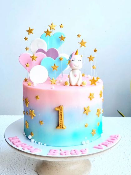 A full view of the unicorn, stars, and hearts cake on its stand.