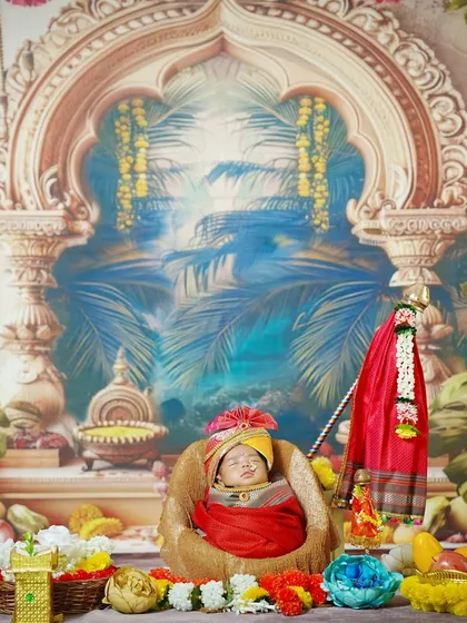 A wide shot of the newborn nestled in a basket, part of our grand Gudi Padwa setup, complete with a miniature Gudi and festive decorations.