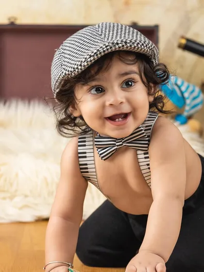A close-up of our dapper little gentleman with piano key suspenders and a charming smile.