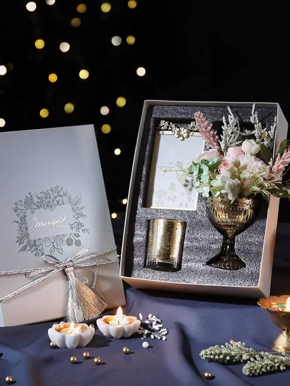 This elegant hamper is designed to brighten Diwali. It includes a votive candle, a flower vase, and a slider box of our delicious hazelnut cookies.