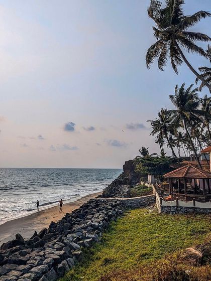The iconic cliffside view of Varkala beach. The combination of lush green cliffs and the blue Arabian Sea is what makes this destination so unique.