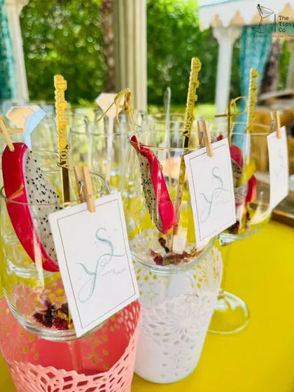 It's all in the details. These drinks are garnished with fresh dragon fruit and personalized tags, served in unique lace-wrapped glasses for a bespoke touch.