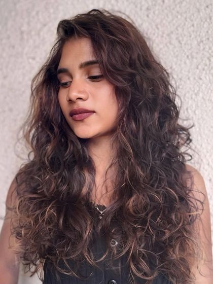 Latte layers and mocha moods. This curly style features a blend of coffee-inspired tones for a rich and delicious-looking result.