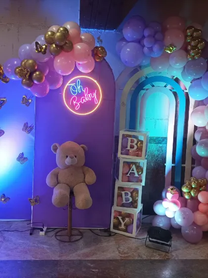 This dreamy baby shower setup features a soft purple and pink color scheme. I used arched panels, a cute teddy bear, 'BABY' blocks, and gold butterfly accents to create a magical and whimsical atmosphere.