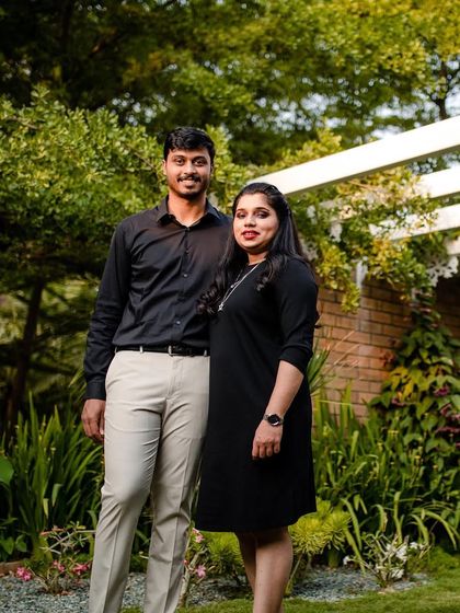 A full-length shot of the couple in a garden. Her simple makeup and hairstyle allow her natural beauty to be the focus, ensuring the photos feel authentic and timeless.