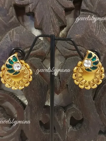 These small Dakshinaya studs are perfect for a subtle yet traditional look. The design features a classic mango motif, or 'kairi', with green enamel work, set in rich gold.