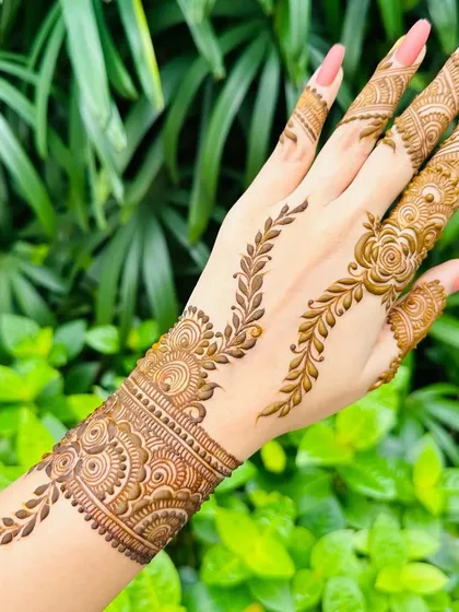 A beautiful example of an elegant party mehandi. This design uses delicate vine and floral patterns, creating a stylish bracelet or 'hathphool' look that is perfect for wedding guests or any festive gathering.