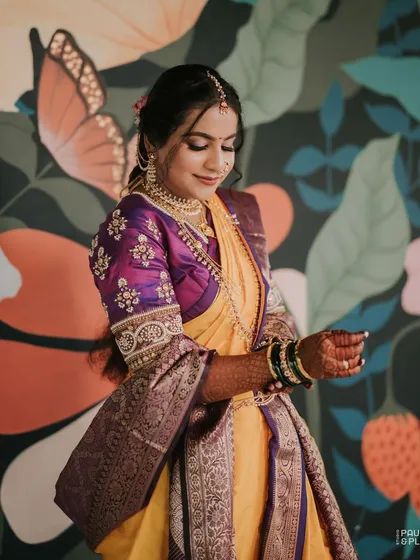 A close-up of the bride's beautifully embroidered blouse and traditional jewelry.