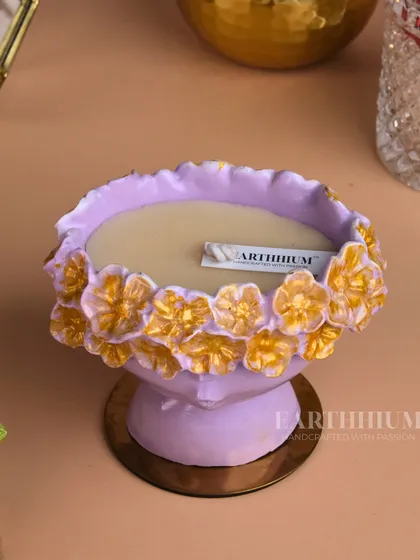 This lilac Jesmonite urli-style candle holder is adorned with golden flowers, blending modern material with traditional design.