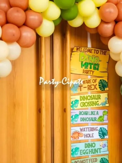 The entrance to the party room was decorated with a balloon arch and a fun 'Dino-Mite Party' signpost.