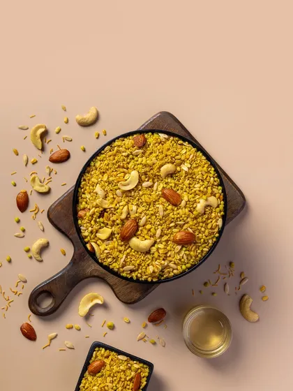 A savory Moong Dal mixture with cashews and almonds. The soft, neutral background is perfect for a clean, minimalist packaging design.