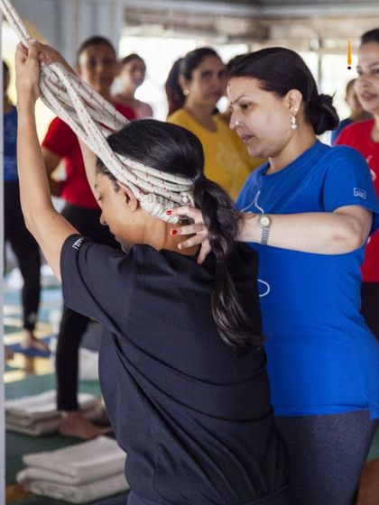 Here, a student uses the wall ropes to decompress her cervical spine. This is a simple yet powerful technique to relieve neck tension and stiffness, a common problem in our modern, gadget-filled lives.