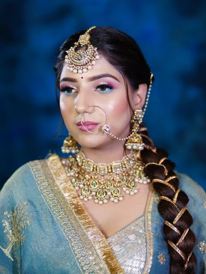A close-up of the peacock-inspired bridal makeup, focusing on the colorful eyeshadow and the braided hairstyle.