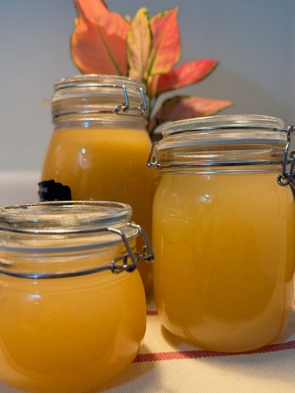 Three jars of our golden-hued fermented drinks, glowing in the light. These are made with care and natural ingredients, offering a healthy and refreshing alternative.