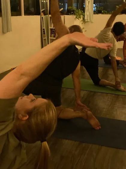 A side view of our students in a flowing sequence, moving with intention and breath. The group energy helps everyone stay motivated.