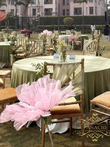 A close-up of the chair decor, featuring a large, whimsical organza flower in a soft pink hue.