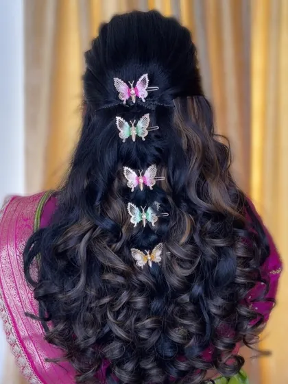 I love when clients want to have fun with their look. This modern, romantic hairstyle features soft curls and whimsical butterfly clips, perfect for an engagement party or reception.