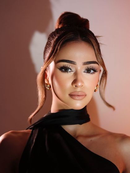 A confident portrait showcasing the bright, highlighted skin and soft glam eye.