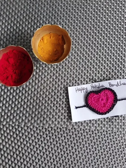 A simple and sweet heart-shaped crochet rakhi.
