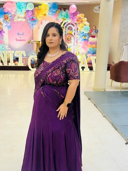 A full-length view of the purple saree gown. The pre-draped style gives the elegance of a saree with the comfort and ease of a gown.