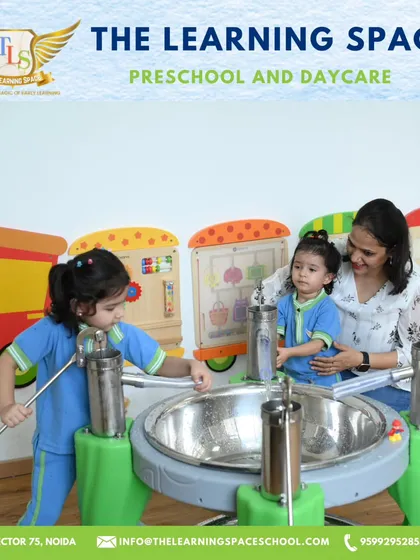 A teacher and two children explore the music station together. I encourage collaborative play, which helps children learn from each other and develop social skills.