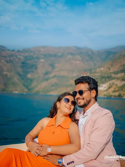 A vibrant, sun-drenched photo of a couple relaxing on a boat on Tehri Lake. This demonstrates our skill in using natural light and stunning landscapes to create beautiful, relaxed couple portraits.