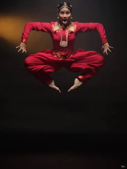 Capturing the peak of energy and expression in a single, frozen moment. This shot from a Bharatnatyam dance session shows the power and discipline of the art form, achieved with precise studio lighting against a dark backdrop.