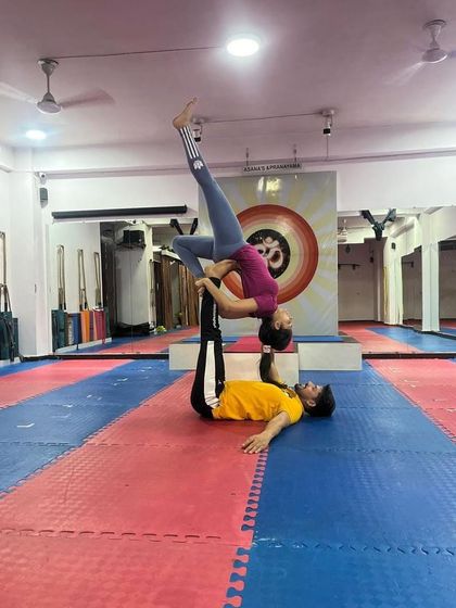 This advanced acro yoga pose requires the flyer to balance in a one-legged inversion. It is a powerful demonstration of the strength and stability of both partners.
