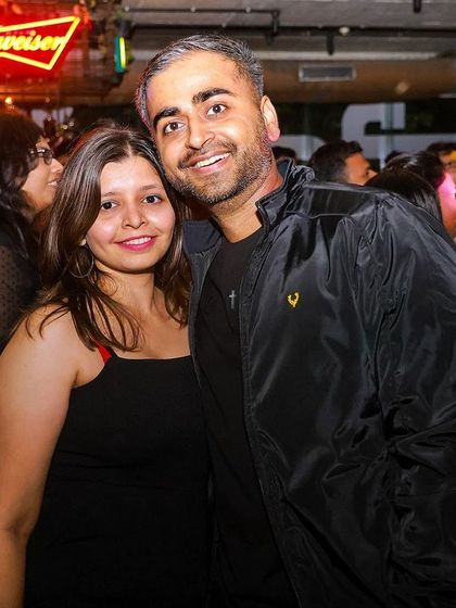 A couple enjoying their night out under the neon lights of the bar at Social. It's a great place for a date night with a difference.