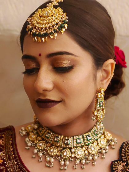 A simple yet stunning look featuring a Pachi Kundan choker with green stones and a matching maang tikka. Ideal for pre-wedding functions.