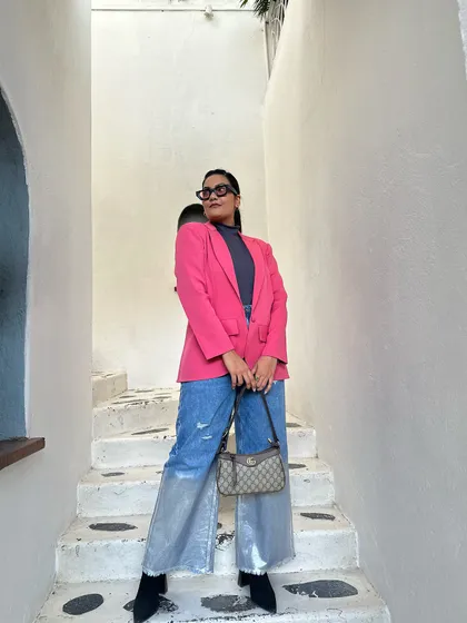 This is a personal style moment. I love playing with bold colors, like this pink blazer, and mixing high-end pieces with high-street finds. This kind of confident, vibrant style is a huge inspiration for my own designs.