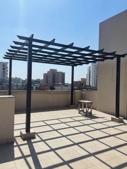 This is the foundational stage of a rafter pergola. The image shows the bare metal structure installed on a rooftop, ready for the next steps of adding flooring, planters, furniture, and lighting.