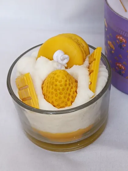 Another view of the yellow dessert candle, highlighting the detailed wax toppings.