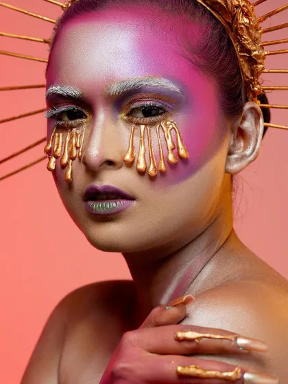 A conceptual portrait titled 'Burning Candles'. This look uses dripping gold makeup effects and creative lighting to create a surreal and artistic image, a style we love to explore in our studio.