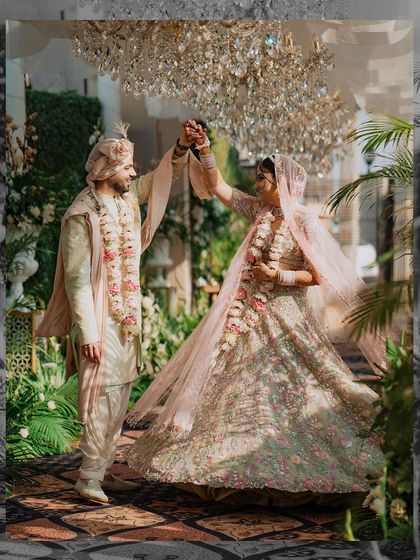 The couple shares a dance in a beautifully decorated corridor. The movement in the bride's lehenga and their joyful expressions make this a dynamic and romantic shot.