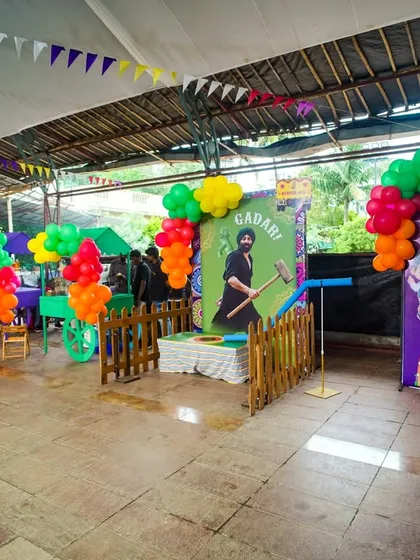 A row of game stalls with a distinct Punjabi flair, including a "Gadari" hammer game and a tattoo station.