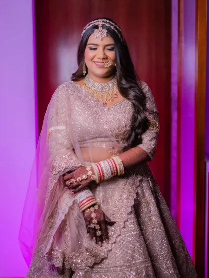 The complete look for Palak. Her soft glam makeup, wavy hair, and stunning lehenga come together to create a modern and elegant bridal vision.