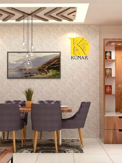 A serene dining space adjacent to a wooden pooja unit. The design features a geometric false ceiling, pendant lights, and comfortable upholstered chairs, creating a warm and inviting atmosphere.