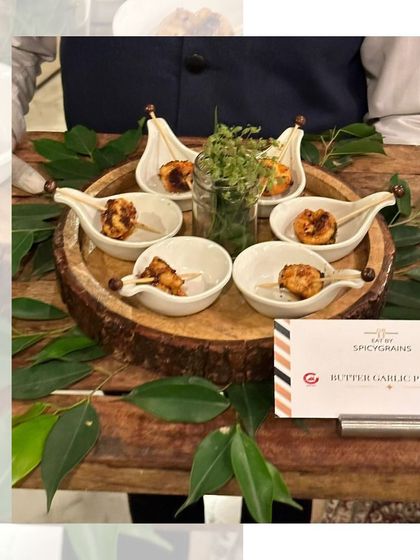 Succulent Butter Garlic Prawns, beautifully presented on a rustic wooden platter with fresh leaves. A simple yet incredibly flavourful appetizer for seafood lovers.