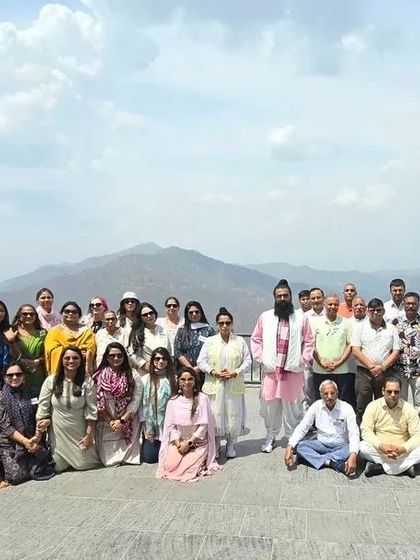 A group photo on a terrace overlooking the mountains in Himachal Pradesh.