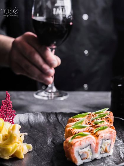 A perfect pairing of red wine with our flame-torched salmon sushi. This image captures the sophisticated, world-class dining experience we are prepared to create for your most cherished moments.