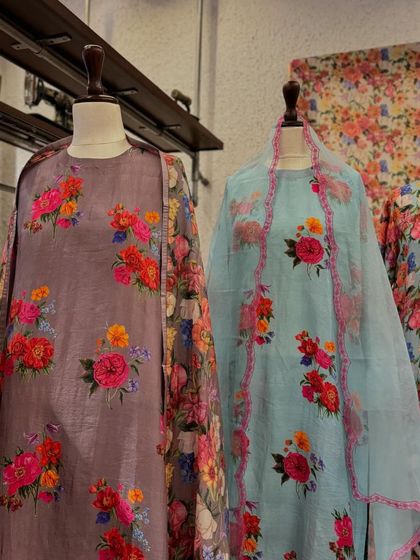 A beautiful collection of floral printed outfits, including a lilac kurta and a pastel blue suit, perfect for the summer season.