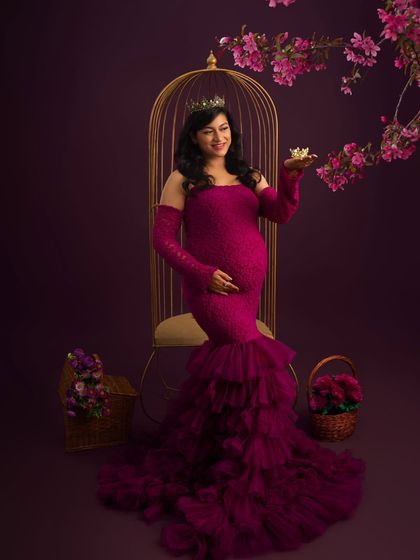 A royal moment. Wearing a crown and a beautiful magenta gown, this mother-to-be holds a tiny crown, symbolizing the little prince or princess she is waiting for.